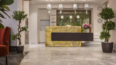 a lobby with a yellow table and potted plants at Hotiday Athens Acropolis in Athens