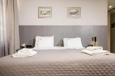 a bedroom with a large bed with white sheets and pillows at Hotiday Athens Acropolis in Athens