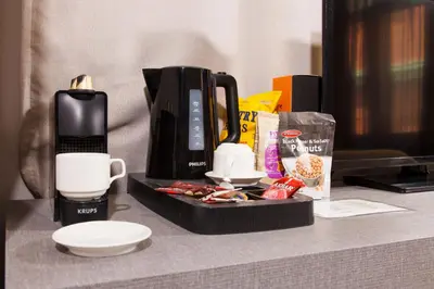 a table with a coffee maker and a cup of coffee at Hotiday Athens Acropolis in Athens