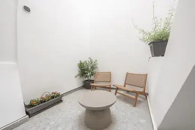 a small courtyard with two chairs and a toilet at Spacious Apartment With Private Garden - Zen Demeter in Athens