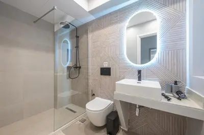 a bathroom with a toilet and a sink and a mirror at Spacious Apartment With Private Garden - Zen Demeter in Athens