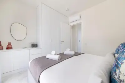 a white bedroom with a bed and a mirror at The HostMaster WiseView Panorama in Athens