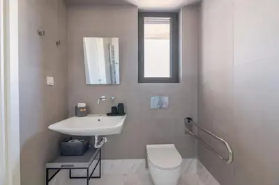 a white bathroom with a sink and a toilet at The HostMaster WiseView Panorama in Athens