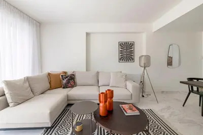 a living room with a white couch and a table at The HostMaster WiseView Panorama in Athens