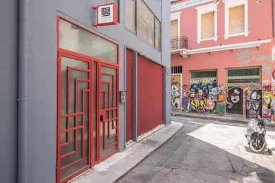 a building with red doors on a street with graffiti at Urban Couples Retreat With Rooftop Access - Zen Selene By Tessera in Athens