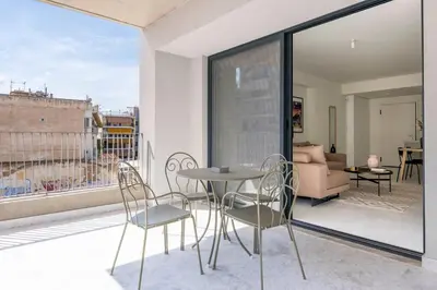 a patio with a table and chairs on a balcony at The HostMaster WiseView Celeste in Athens
