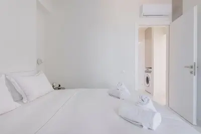 a white bedroom with white towels on a bed at The HostMaster WiseView Celeste in Athens