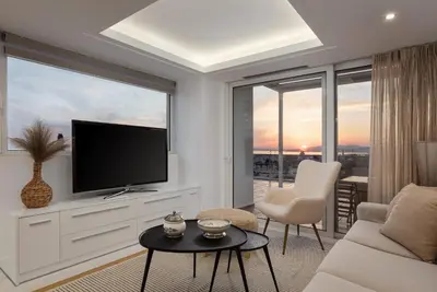 a living room with a large window with a tv at Ellinikon 360 Roof Top in Athens