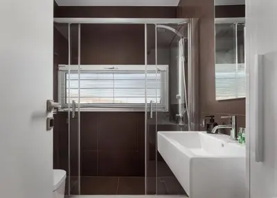 a bathroom with a glass shower and a sink at Ellinikon 360 Roof Top in Athens