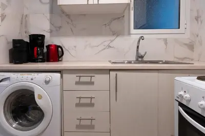 a kitchen with a washing machine and a sink at Cozy Nest in Athens