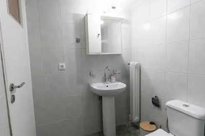 a white bathroom with a sink and a toilet at Cozy Nest in Athens
