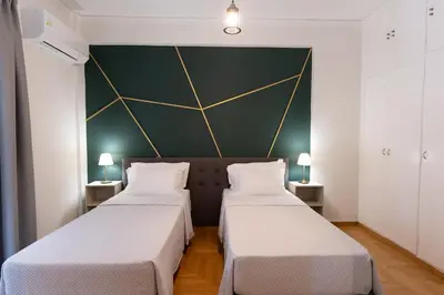 two beds in a room with a green wall at Cozy Nest in Athens