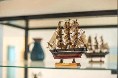a model boat sitting on a glass table at Bright & Airy Family Studio with Rooftop Access - Zen Theia by Tessera in Athens