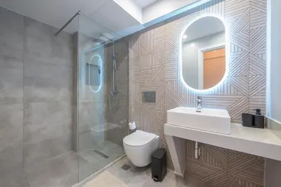 a bathroom with a toilet and a sink and a mirror at Bright & Airy Family Studio with Rooftop Access - Zen Theia by Tessera in Athens