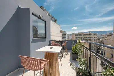 a balcony with a table and chairs on a building at Bright & Airy Family Studio with Rooftop Access - Zen Theia by Tessera in Athens