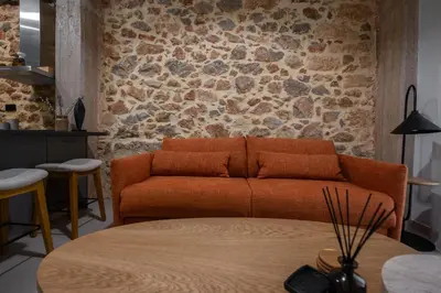 an orange couch in a room with a stone wall at Unique & Stylish Living in Kipseli in Athens
