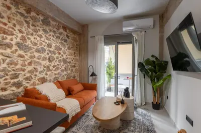 a living room with a couch and a stone wall at Unique & Stylish Living in Kipseli in Athens
