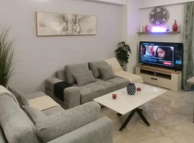 a living room with two couches and a tv at Keti's Elite in Athens