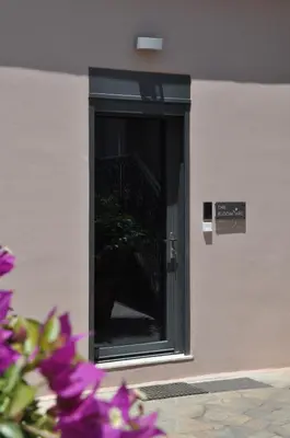 a door to a building with purple flowers in front of it at The BloomYard in Markopoulo