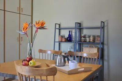 a dining room table with a vase of flowers and fruit at The BloomYard in Markopoulo