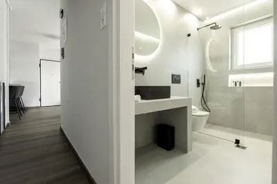 a white bathroom with a sink and a toilet at Glyfada Aelia Prestige in Athens