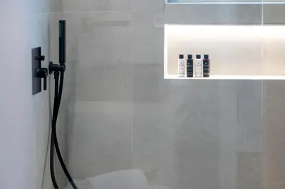 a shower with a black hose in a bathroom at Glyfada Aelia Prestige in Athens