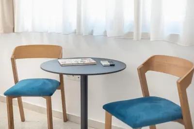 a table with two chairs and a book on it at Peaceful Couples Apartment & Rooftop Access - Zen Hebe By Tessera in Athens
