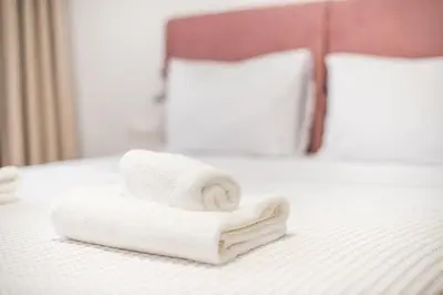 a pile of towels sitting on top of a bed at Urban Getaway Cozy Open Space & Rooftop Lounge Zen Artemis By Tessera in Athens