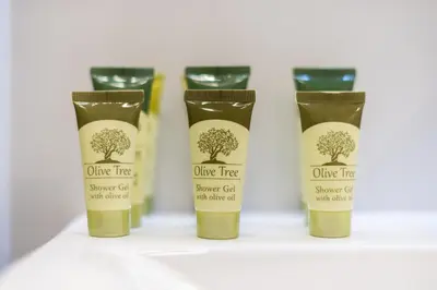 a group of four bottles of olive tree shower gel at Urban Getaway Cozy Open Space & Rooftop Lounge Zen Artemis By Tessera in Athens