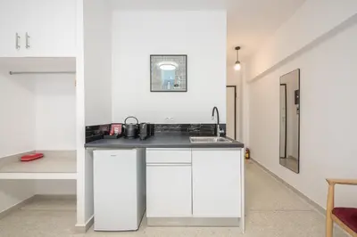 a kitchen with white cabinets and a sink at Urban Getaway Cozy Open Space & Rooftop Lounge Zen Artemis By Tessera in Athens
