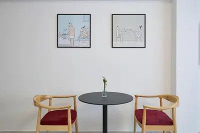 a table and two chairs in a room with two pictures at Urban Getaway Cozy Open Space & Rooftop Lounge Zen Artemis By Tessera in Athens