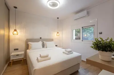 a bedroom with a white bed with towels on it at The Secret Garden Stay in Athens