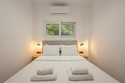 a bedroom with a large white bed with two pillows at The Secret Garden Stay in Athens