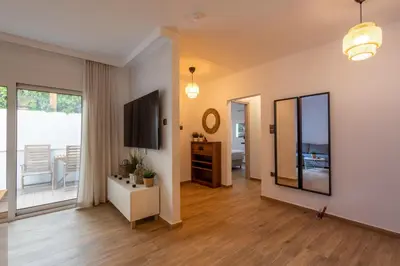 a living room with a mirror and a television at The Secret Garden Stay in Athens