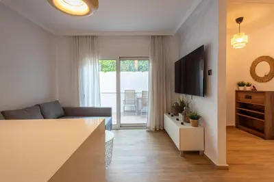 a living room with a couch and a television at The Secret Garden Stay in Athens