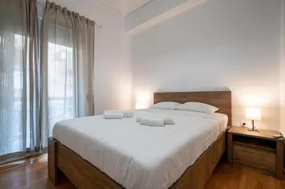a bedroom with a large bed with white sheets and pillows at Clio 3BR apartment in Kypseli by ΜΡS in Athens