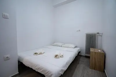 a white bed with three dogs on it at Clio 3BR apartment in Kypseli by ΜΡS in Athens