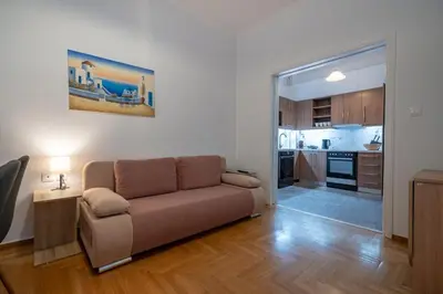 a living room with a couch and a kitchen at Clio 3BR apartment in Kypseli by ΜΡS in Athens
