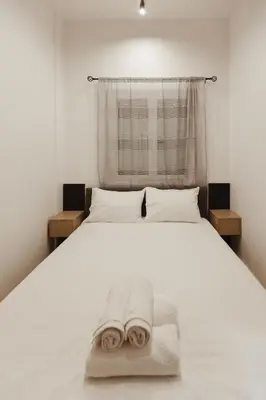 a bedroom with a white bed with towels on it at Irida apartment in Athens
