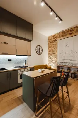 a kitchen with a counter and a table and chairs at Irida apartment in Athens