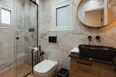 a bathroom with a sink and a toilet and a mirror at Irida apartment in Athens