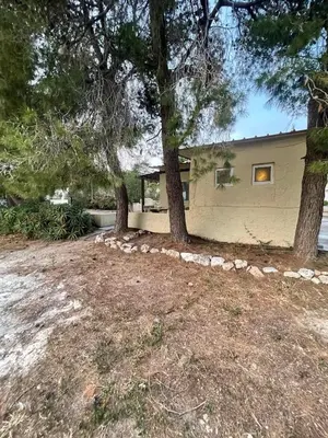 a house with two trees in front of it at The Simple Space, a pause near the sea in Ayía Paraskeví