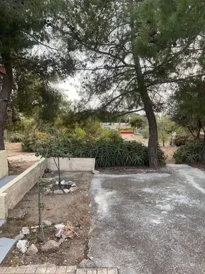 a parking lot with a tree in a park at The Simple Space, a pause near the sea in Ayía Paraskeví