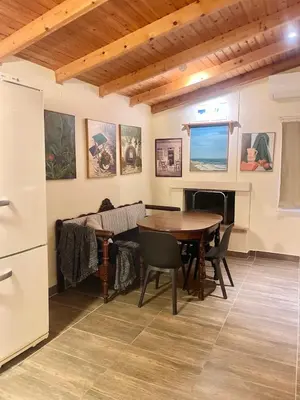 a living room with a table and a couch at The Simple Space, a pause near the sea in Ayía Paraskeví