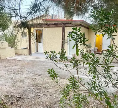 a small yellow house with a yellow door at The Simple Space, a pause near the sea in Ayía Paraskeví