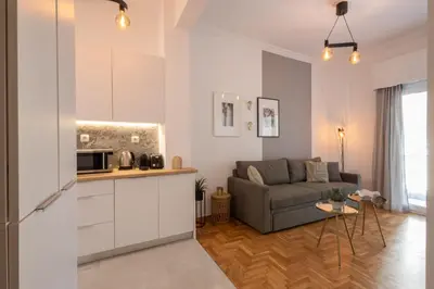 a kitchen and a living room with a couch at Fresh 2 bdrm Apt in Koukaki in Athens