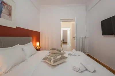 a bedroom with a white bed with towels on it at Fresh 2 bdrm Apt in Koukaki in Athens