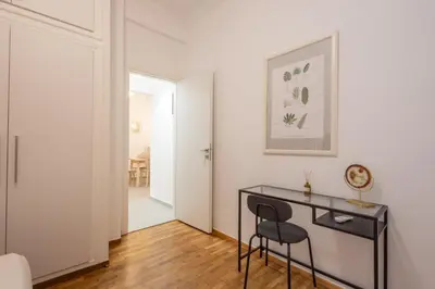 a white room with a black desk and a chair at Fresh 2 bdrm Apt in Koukaki in Athens