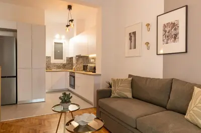 a living room with a couch and a kitchen at Fresh 2 bdrm Apt in Koukaki in Athens