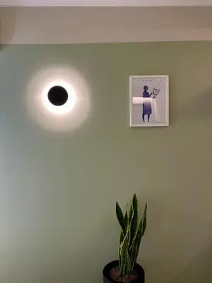 a light on a green wall with a plant at Aura, Sis Urban Apartments III in Athens